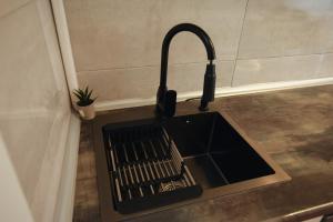 a sink with a faucet in a kitchen at M&S Central Residence in Bitola +81 photos