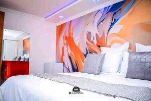a bedroom with a bed with a painting on the wall at tp guesthouse in Phomolong