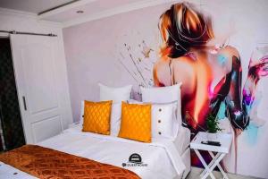 a bedroom with a large painting of a woman on the wall at tp guesthouse in Phomolong