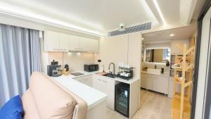 a white kitchen with a couch and a stove at Luxury Capsule Haus Phuket in Panwa Beach