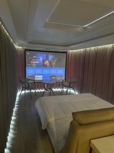 a bedroom with a bed and a large screen at Luxury Capsule Haus Phuket in Panwa Beach