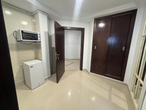 a room with a hallway with a door and a microwave at Le Charbon Mystique in Sfax