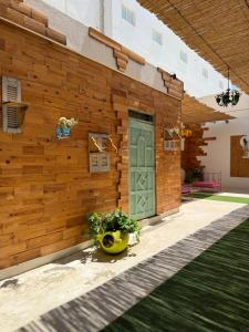 a wooden wall with a green door on a building at Le Charbon Mystique in Sfax