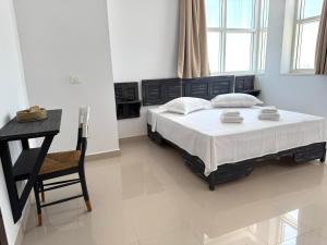 a bedroom with a bed and a table and a chair at Le Charbon Mystique in Sfax