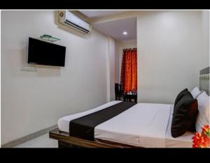 a bedroom with a bed and a television in it at Hotel Om Sai And Lodging in Panvel
