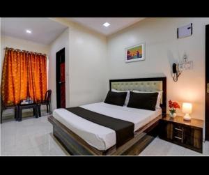 a bedroom with a bed and a table and a chair at Hotel Om Sai And Lodging in Panvel