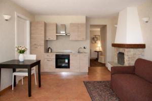 a kitchen and living room with a couch and a table at LA CASA DI TALIN - Camere e appartamenti - Accoglienza adults only in Serravalle delle Langhe