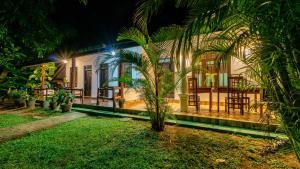 a house with a palm tree in front of it at Sigiri Binara Villa in Sigiriya