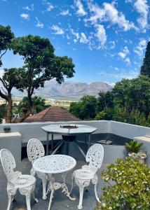 a table and chairs on a patio with a view of the mountains at Paarl View House in Paarl