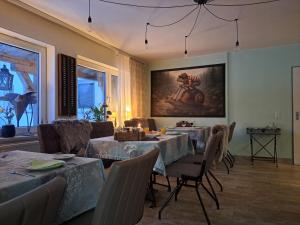 a dining room with tables and chairs and a painting on the wall at Holl & Boll in Clausthal-Zellerfeld