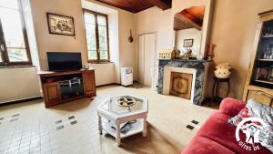 a living room with a couch and a fireplace at Laguzou in Saint-Julien-de-Briola