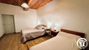 two beds in a room with wooden floors at Laguzou in Saint-Julien-de-Briola