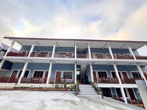 a large blue building with white columns and balconies at Keomisay in Nongkhiaw +5 photos