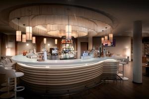 a bar in a restaurant with white chairs at Alpin Chalets Oberjoch in Bad Hindelang