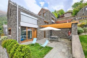a patio with a table and chairs and an umbrella at house with 3 bedrooms T5 in Bellano