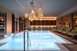 a pool in a hotel with chandeliers at Alpin Chalets Oberjoch in Bad Hindelang