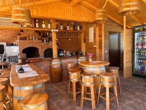 a bar with wooden stools and a counter in a room at Casa Alexia in Potoc +23 photos