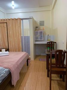 a room with a bed and a table and chairs at Cardo Rooms 2 minutes walk from the beach in General Luna