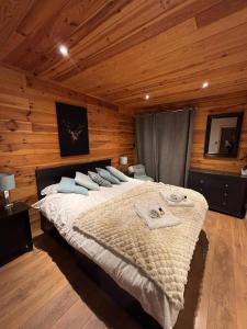 a bedroom with a large bed in a wooden room at Boutique Alpine Chalet with Panoramic Views in Thollon