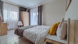 a bedroom with a bed with a yellow pillow at Rezydencja Pod Ochorowiczówką B&B in Wisła