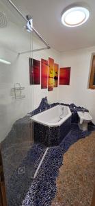 a bathroom with a bath tub and a toilet at Ferienwohnung Baumgartner in Aigen im Ennstal +5 photos