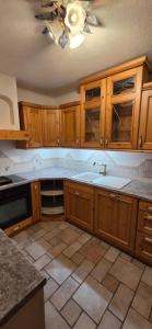 a kitchen with wooden cabinets and a ceiling fan at Ferienwohnung Baumgartner in Aigen im Ennstal