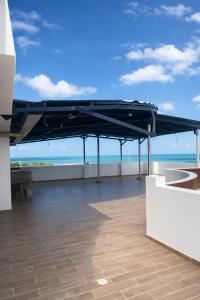 a large black canopy on top of a building with the ocean at Adele Hotel in Ríohacha