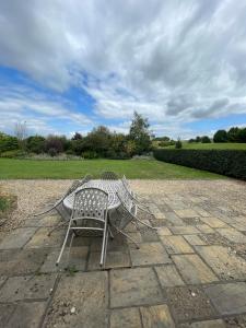 a table and chair sitting on a stone patio at Cumberwell Cottages-Dash Corner in South Wraxall