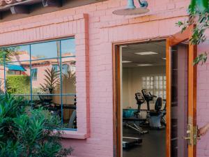 a pink building with a gym with exercise equipment at Arizona Inn in Tucson