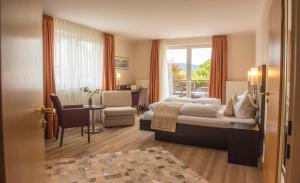 a hotel room with a bed and a table and chairs at Hotel-Restaurant Birkenhof in Bad Soden-Salmünster +64 photos