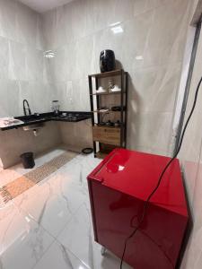 a room with a red table and a counter at JB condominio b in Maceió
