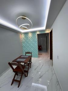 a table and a bench in a room with a ceiling at JB condominio b in Maceió
