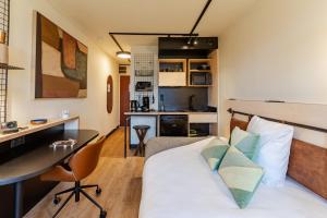 a room with a bed and a desk and a kitchen at Cowool Compiègne in Compiègne
