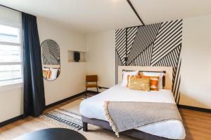 a bedroom with a large bed and a window at Cowool Compiègne in Compiègne
