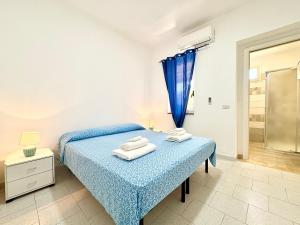 a bedroom with a blue bed with towels on it at Residence Araba Fenice Tropea in Tropea