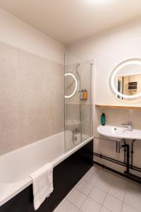 a bathroom with a bath tub and a sink at Cowool Compiègne in Compiègne +38 photos
