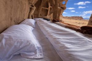 a group of pillows lined up in a cave at Wadi Rum Cave Camping in Wadi Rum