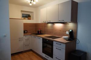 a kitchen with white cabinets and a stove top oven at Moor and More Loft in Monschau