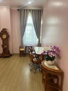 a living room with a table and a clock at Huỳnh Thảo in Vũng Liêm