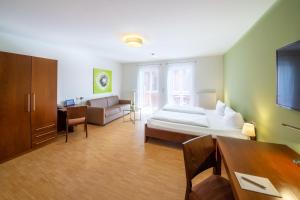 a living room with a bed and a couch at ACANTUS Hotel in Weisendorf +12 photos