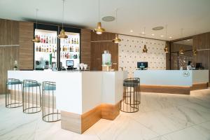 a bar in a restaurant with a counter and stools at AJ Gran Alacant by SH Hoteles in Santa Pola