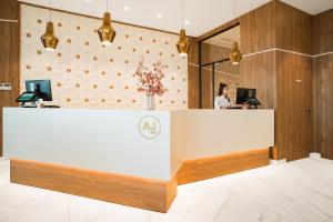 a woman standing behind a reception desk in a lobby at AJ Gran Alacant by SH Hoteles in Santa Pola