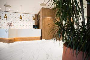 a lobby with a white counter and a potted plant at AJ Gran Alacant by SH Hoteles in Santa Pola