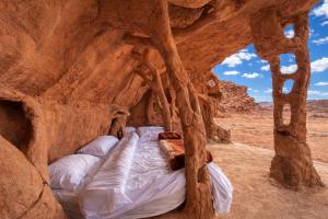 a bed in a cave in the desert at Wadi Rum Cave Camping in Wadi Rum
