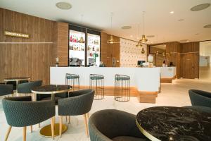a restaurant with tables and chairs and a bar at AJ Gran Alacant by SH Hoteles in Santa Pola