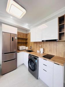 a kitchen with a refrigerator and a washing machine at Och Service Apartment in Ulaanbaatar
