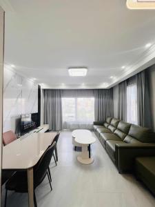 a living room with a couch and a table at Och Service Apartment in Ulaanbaatar