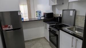 a small kitchen with a sink and a refrigerator at 1brm,2bdrm,3bdrm Palm Ridge Heavens Vipingo in Kilifi