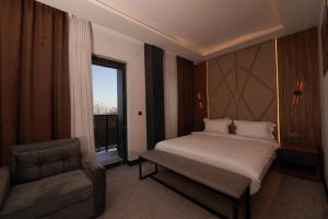 a bedroom with a bed and a chair and a window at Hotel Global Palace in Haskovo +27 photos