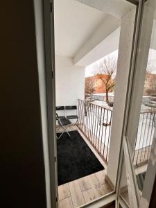an open door to a balcony with a black rug at Apartament Central Wałcz Residence in Wałcz +8 photos